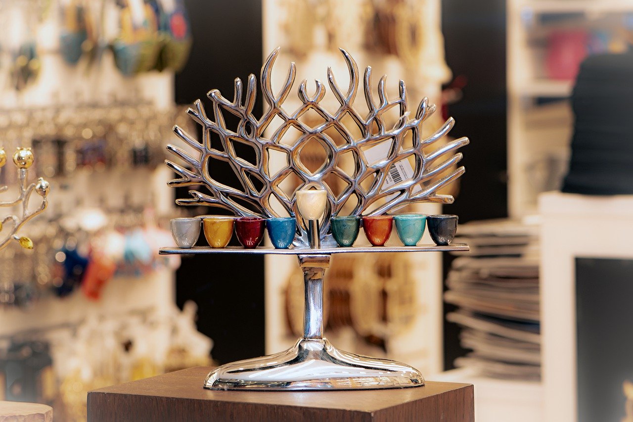 A menorah in rainbow candle cups and a silver leafless tree