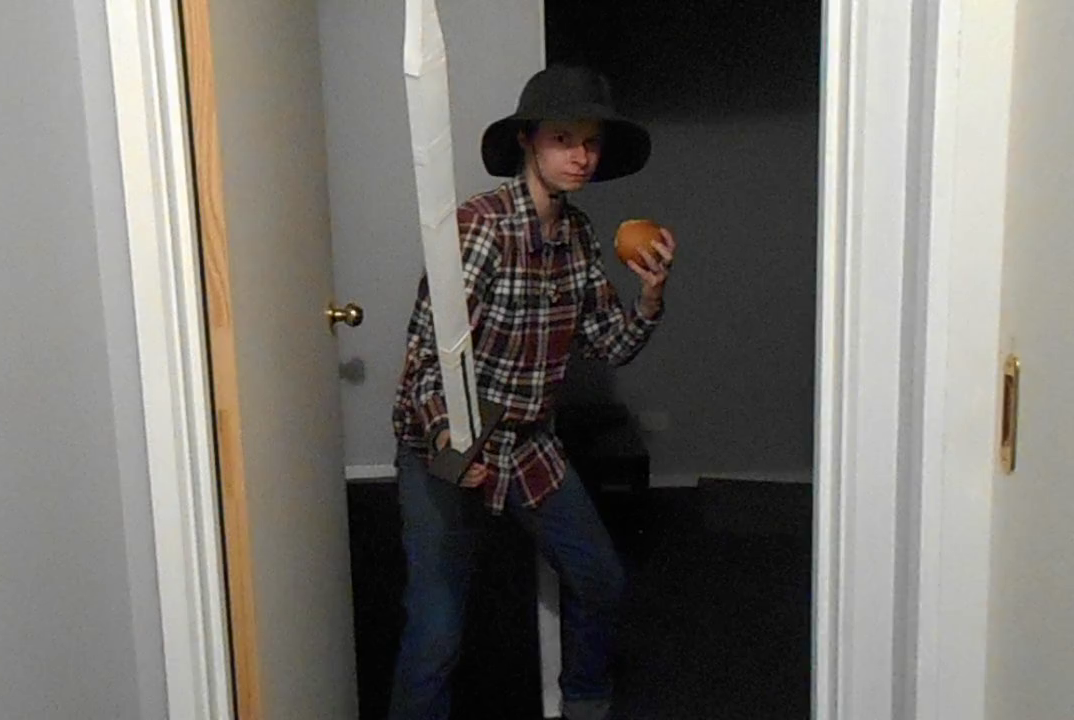 A person in a big hat and oversized plaid shirt, defending a hallway, armed with a giant sword and a sandwich