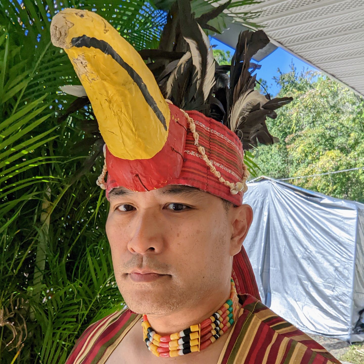 A man in traditional Filipino dance costume with bird headdress